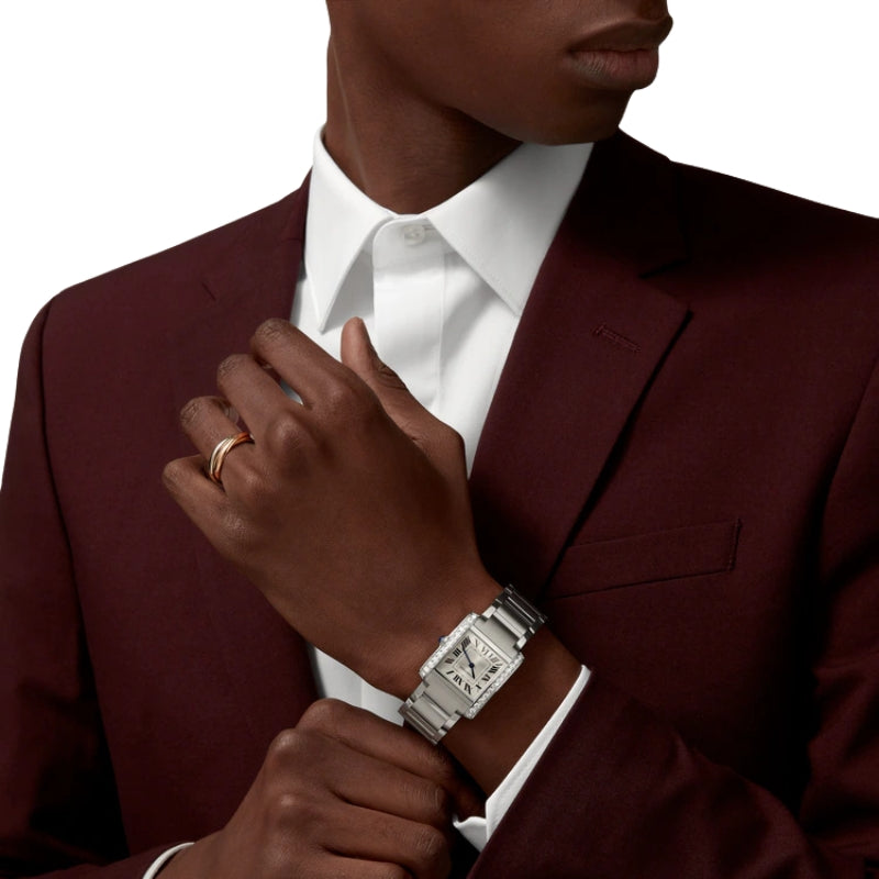 Man wearing silver diamond watch and gold ring.