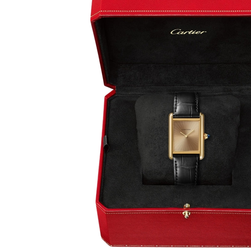 Gold Cartier watch in a red luxury box.