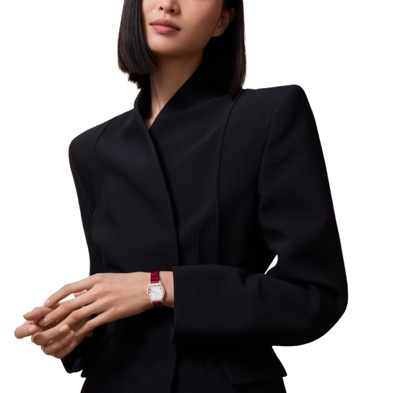 Woman wearing small Cartier Tortue watch on wrist.