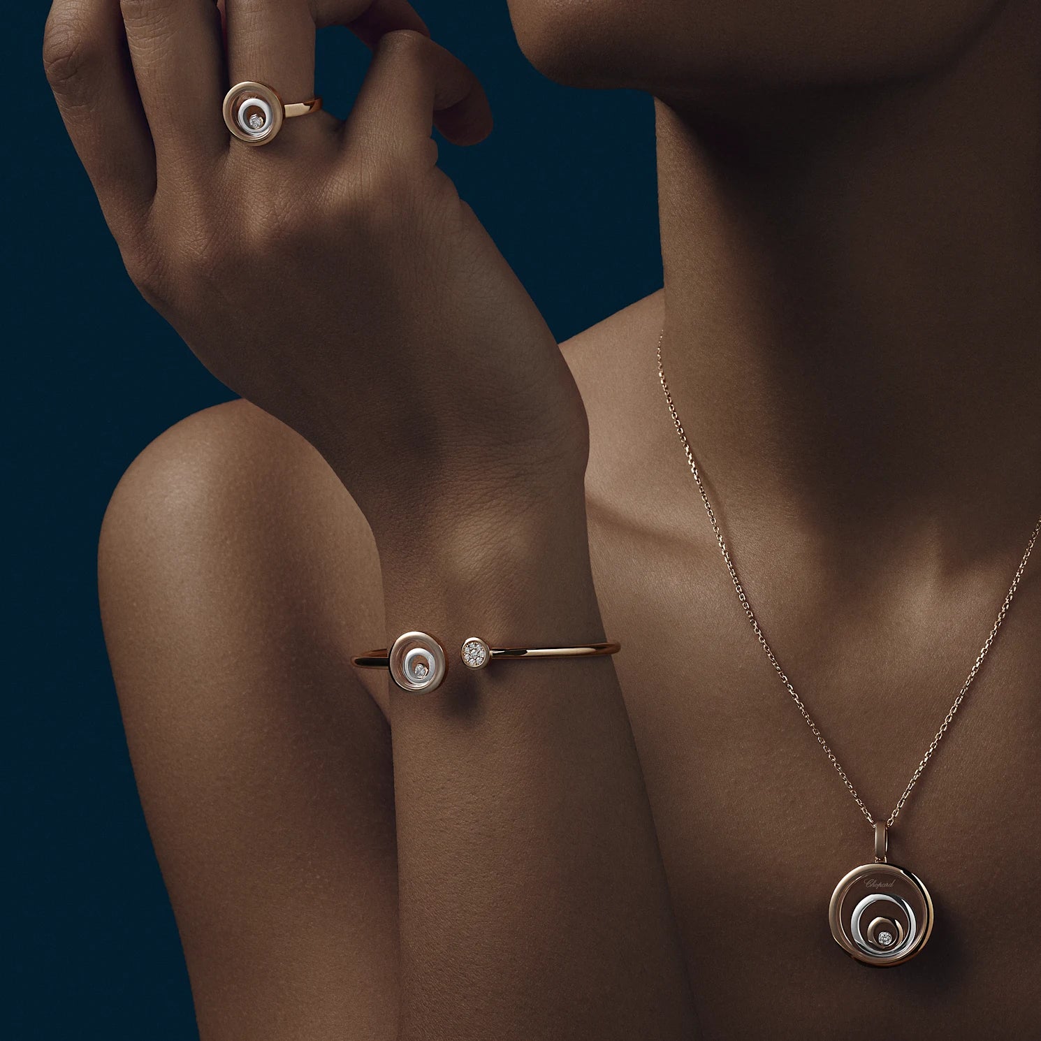 A woman wearing a rose gold necklace, matching bracelet, and rings.