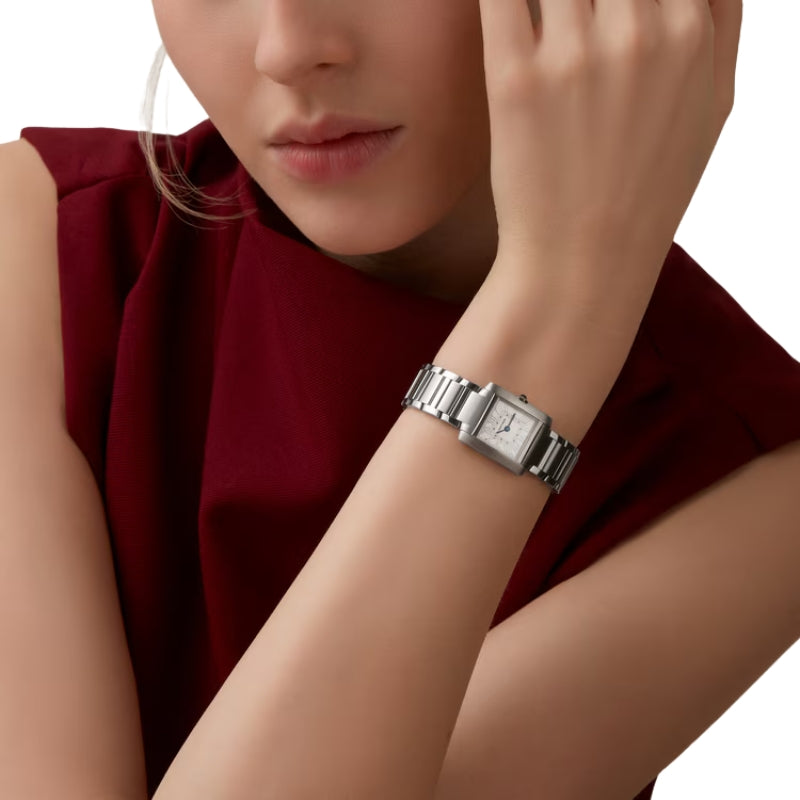 Woman wearing silver Cartier watch on her wrist.