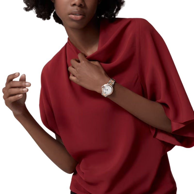 Woman wearing two-tone luxury watch with red top.