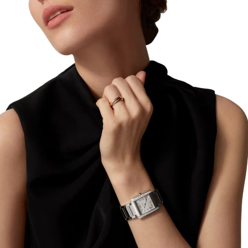 Woman wearing silver diamond watch and gold ring.