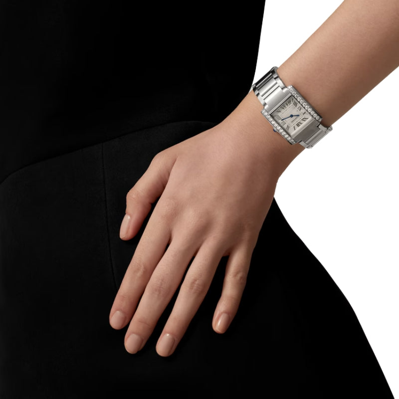 Silver diamond watch worn on a woman's wrist.