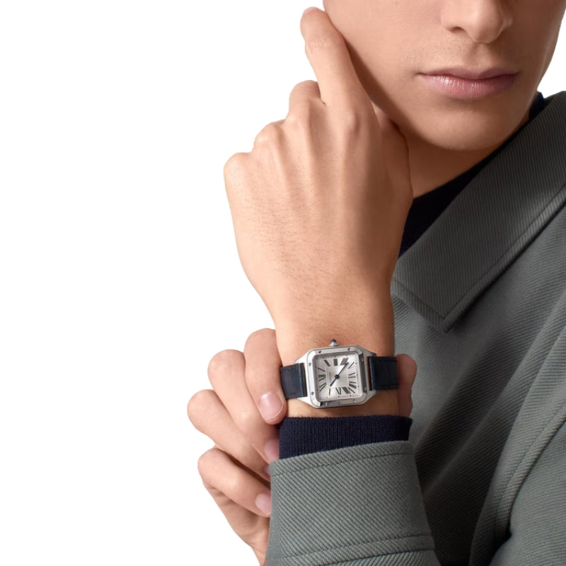 Man wearing silver Cartier watch with blue strap.