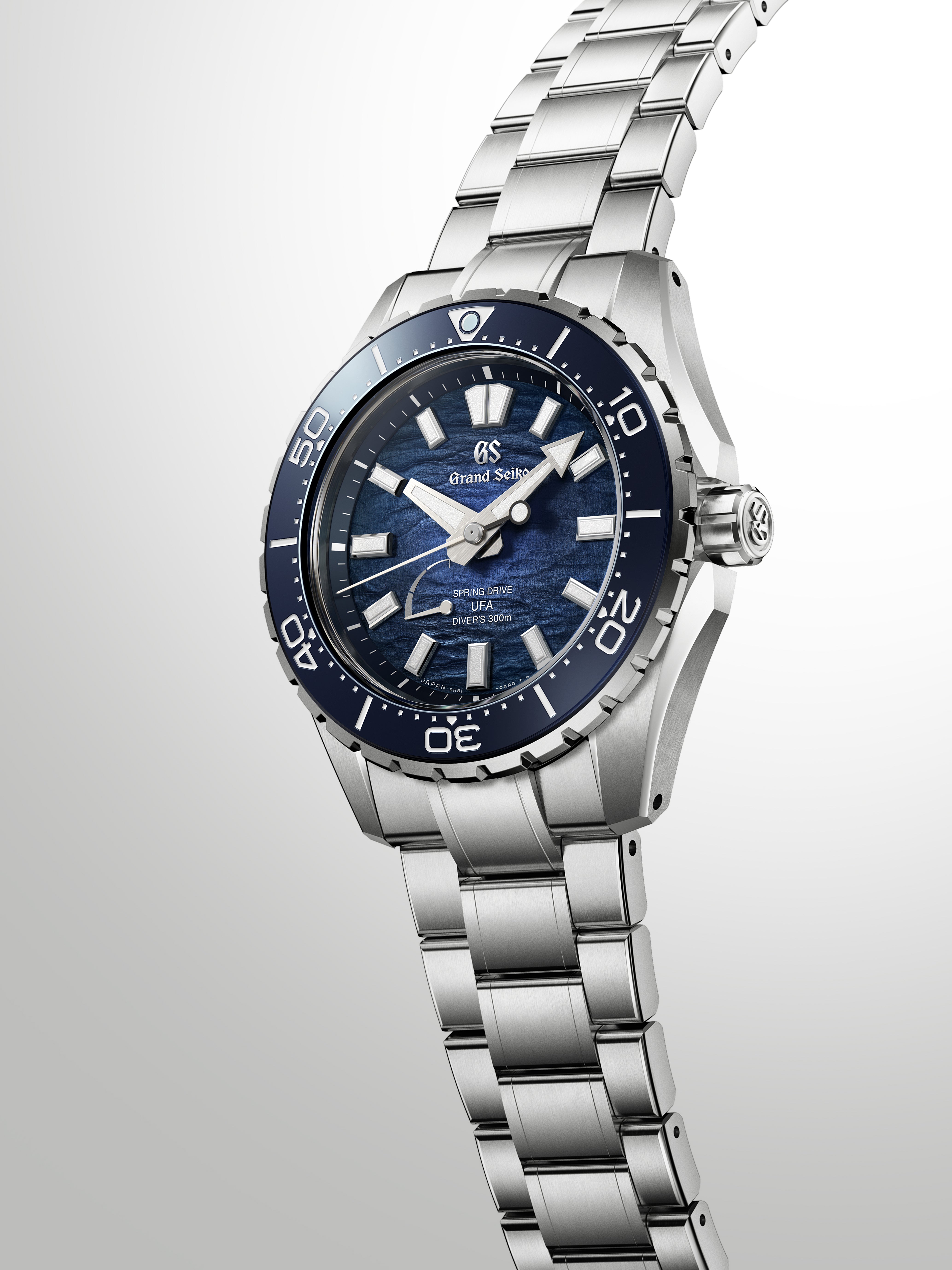 Dramatic editorial lighting highlights the sharp edges and silver markers of the watch.
