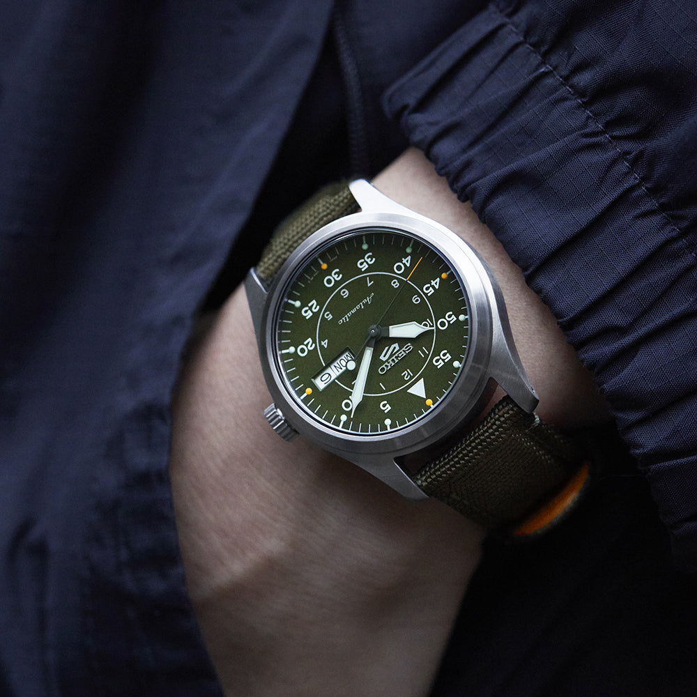 Seiko field watch on green bomber jacket