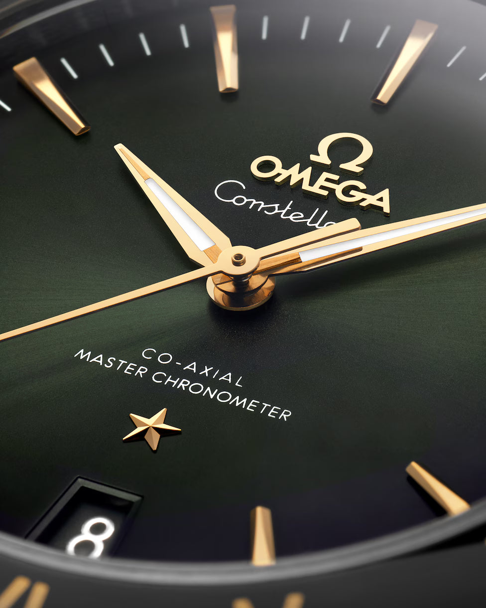 Close-up of green dial with gold watch hands.