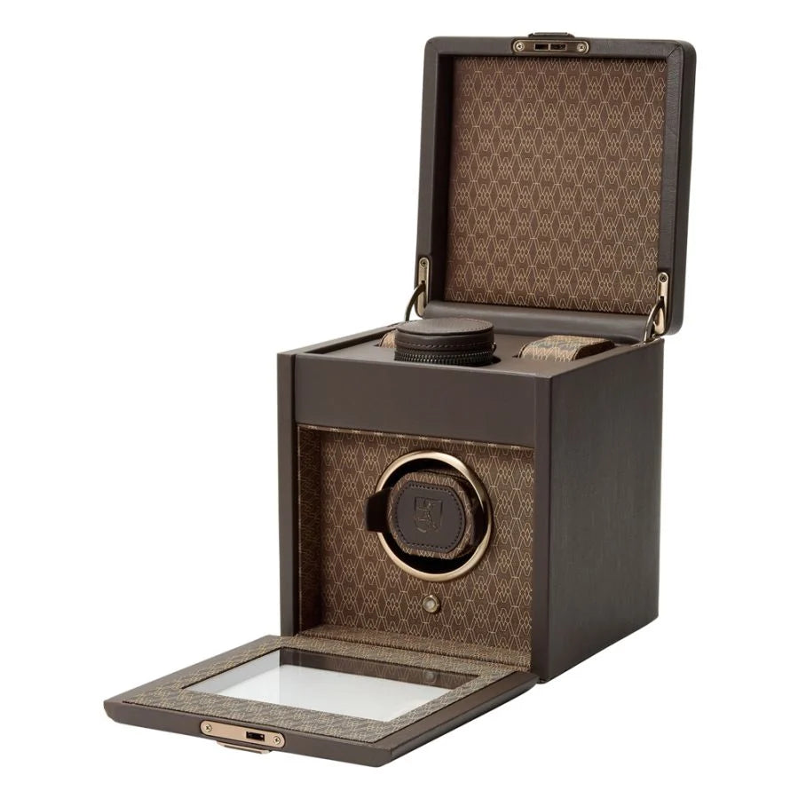 Open view of a watch winder box with accessories placed inside.