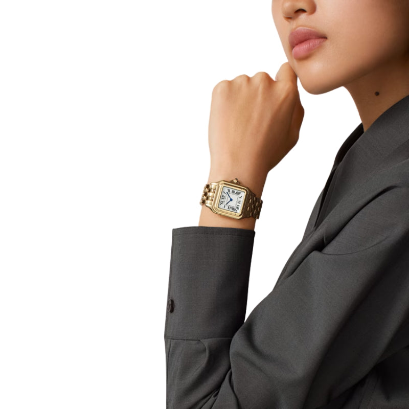 Gold Cartier Panthère watch worn on female wrist.
