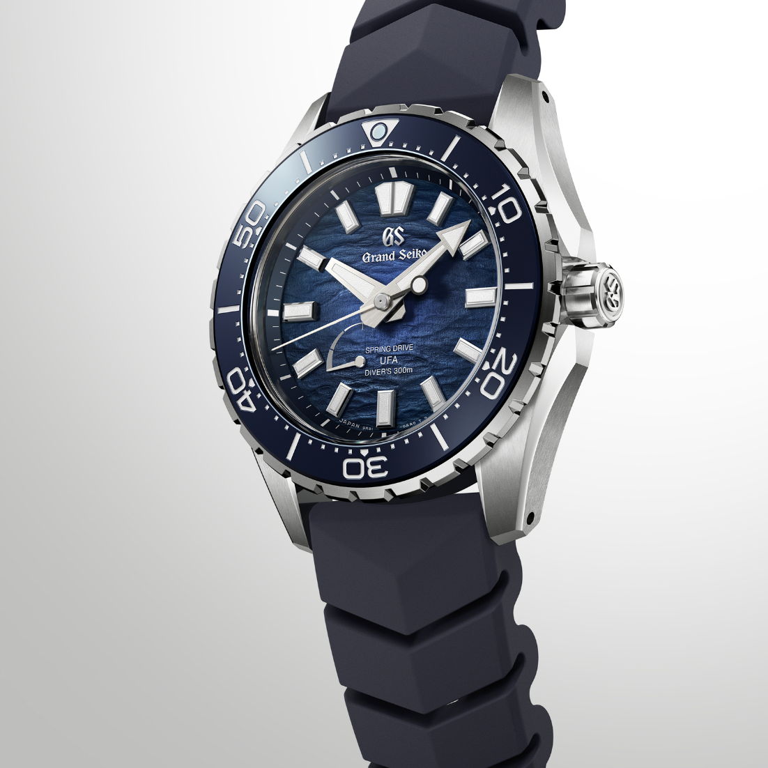 Dramatic editorial lighting highlights the sharp edges and silver markers of the watch.