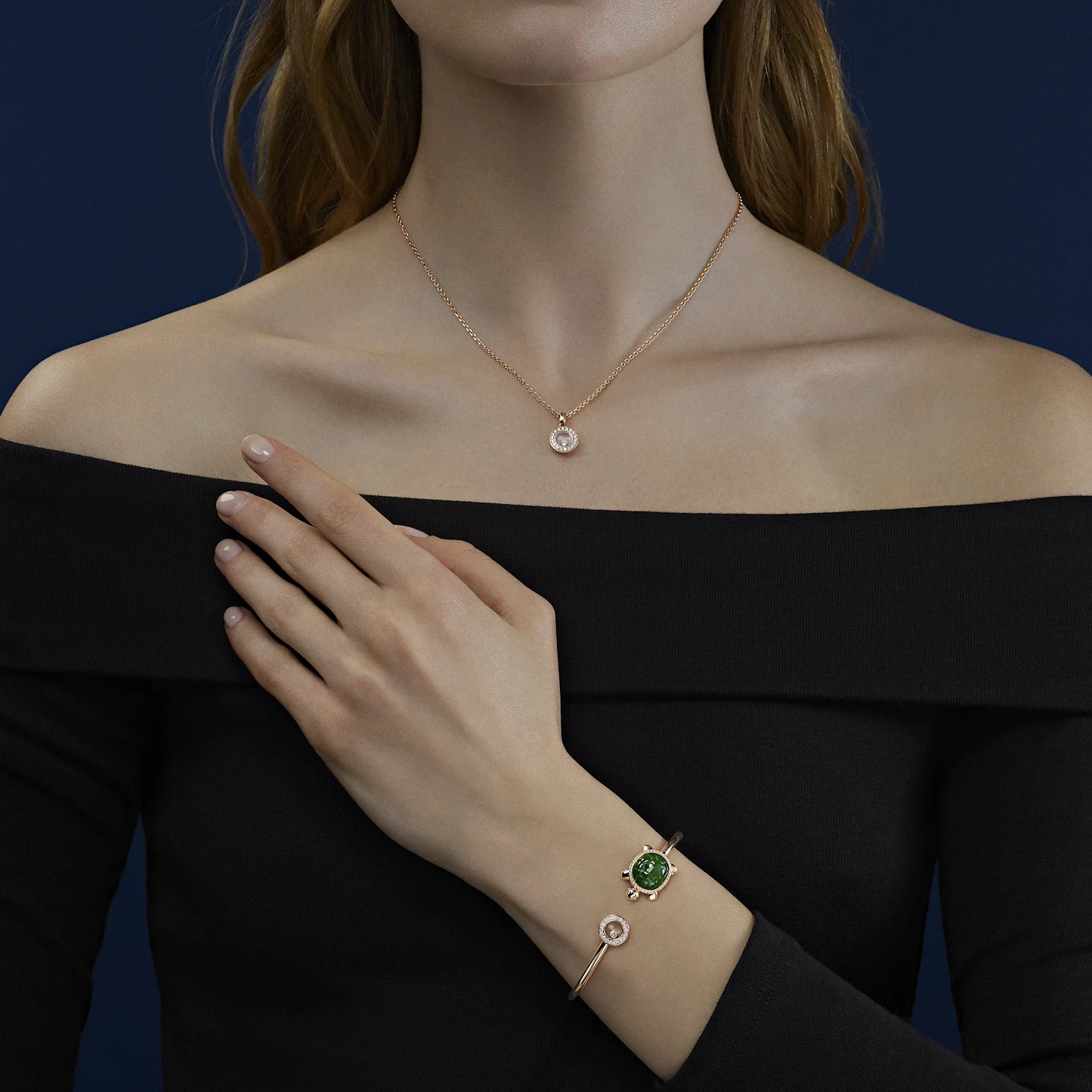 A woman wearing the gold diamond necklace with an off-the-shoulder black dress.