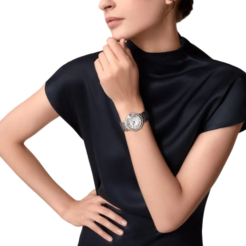 Woman wearing a silver luxury watch on wrist.