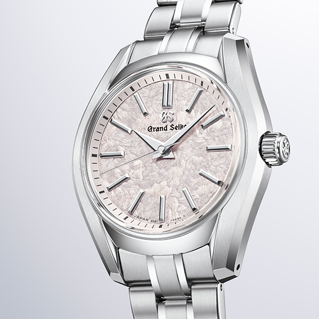 Three-quarter view highlighting the polished bezel and stainless steel integrated watch bracelet.