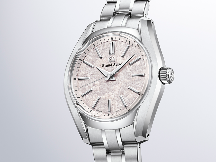 Three-quarter view highlighting the polished bezel and stainless steel integrated watch bracelet.