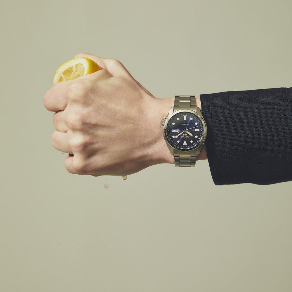 Man wearing Seiko watch squeezing lemon