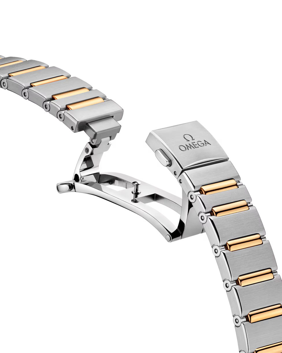 Angled view of watch bracelet with gold links.